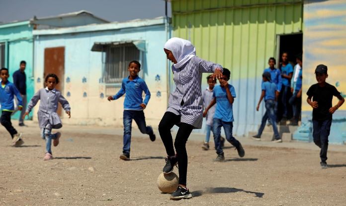 طلبة فلسطينيون يلعبون كرة القدم في مدرستهم في غور الأردن بالضفة الغربية المحتلة يوم الأربعاء. تصوير: محمد تركمان - رويترز